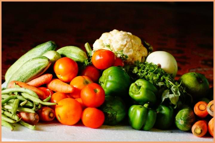 Fresh vegetables including tomatoes, carrots, green peppers, and more.